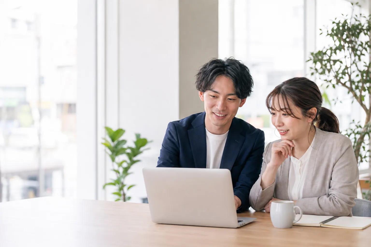 ノートパソコンで求人を見ながら話す2人